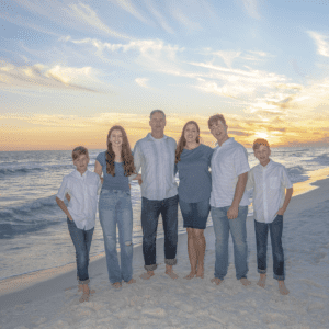 The Bess family (Sara and Sean with their four kids)on a beach during sunset.